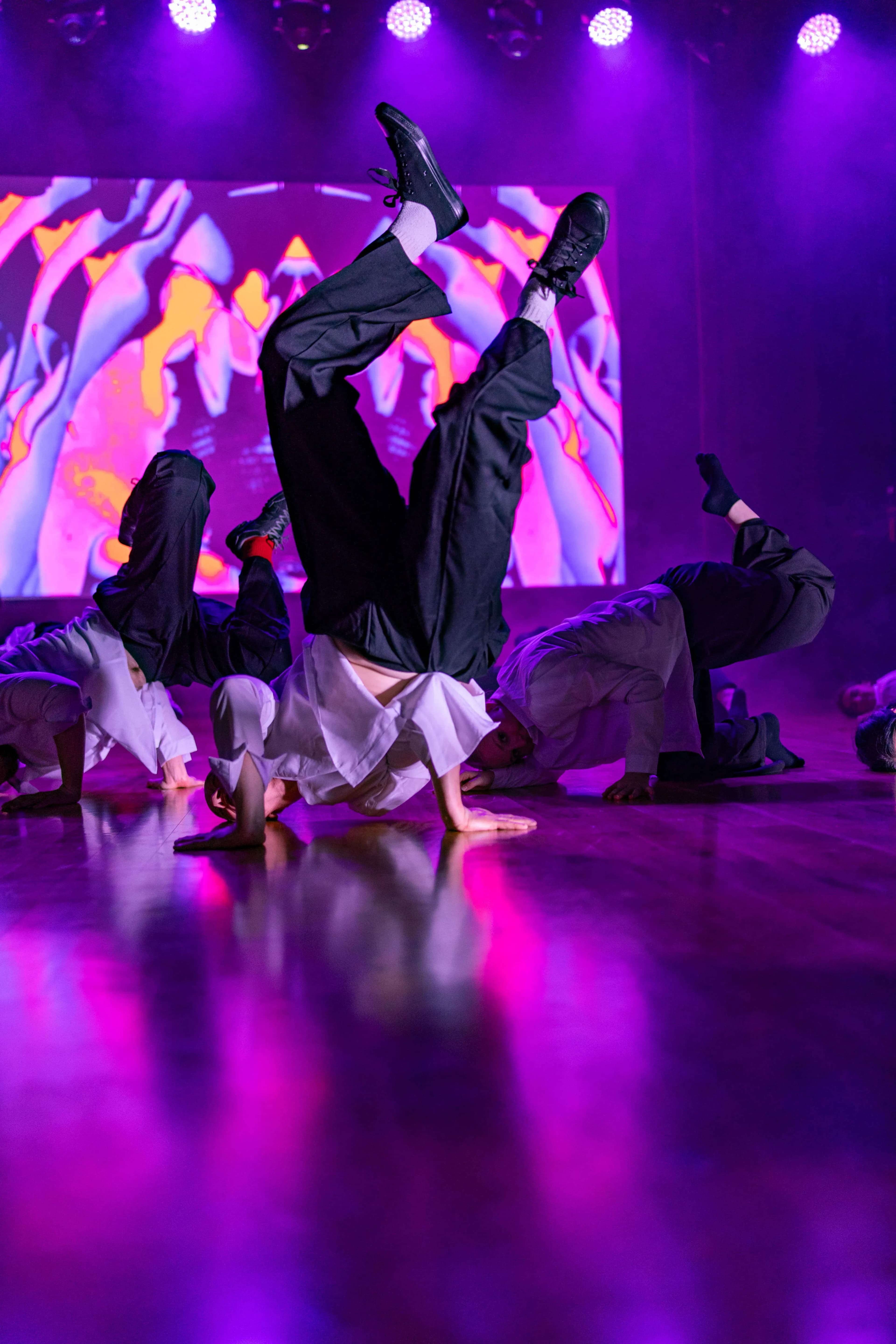 Tancerz zastyga w hip-hopowej pozie do góry nogami